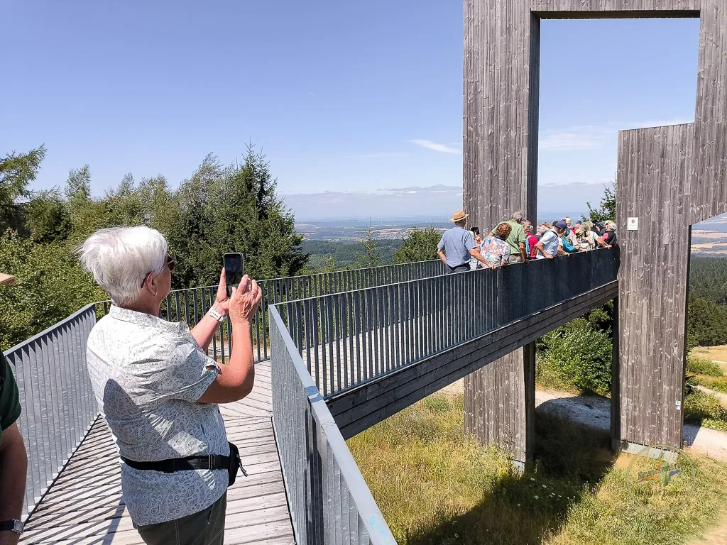 Reisegruppe auf dem Steg der Windklang-Skulptur am Erbeskopf